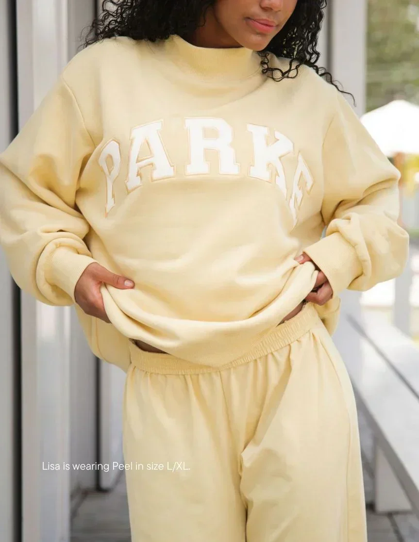 Sudadera Varsity de cuello alto amarillo pastel con letras blancas